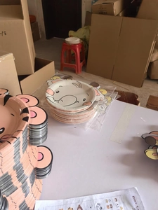 Stack of farm animal shaped paper plates showing elephant and tiger designs in detail