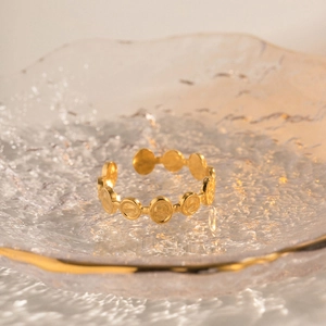 Detail of 18k gold-plated stainless steel ring with interlocking coin-textured circles