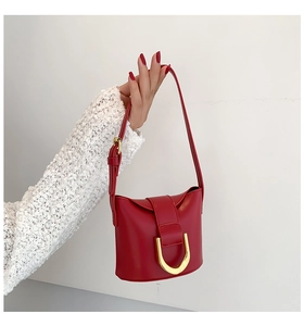 Detail view of red leather crossbody bag featuring a premium gold U-shaped metal lock closure