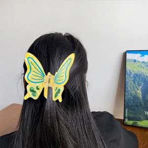 Elegant yellow butterfly hair claw with colorful patterns worn on a model's hair