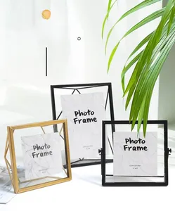 Détail d'un cadre photo géométrique nordique en métal avec verre rotatif et fini doré