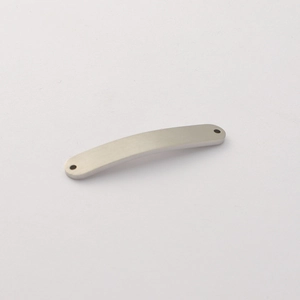 Macro shot of curved brushed titanium steel connector pendant with dual attachment holes