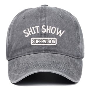 Close-up of SHIT SHOW white 3D embroidery on vintage washed dark grey baseball cap