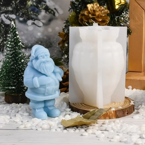 Makroansicht der Weihnachtsmann-Silikonform und fertiges Ornament aus Gips in Hellblau