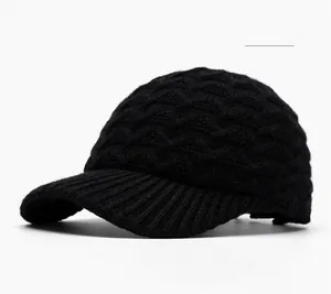 Detailed view of black knitted baseball cap featuring heavy textured wave pattern