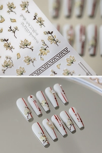 Detail of white magnolia nail stickers with 3D pearls and red line art on long coffin nails