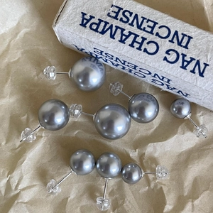 Close-up of silver-gray pearl earrings in various sizes with sterling silver pins