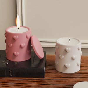 Detail of 3D heart embossed scented candle jars in pink and white matte finish