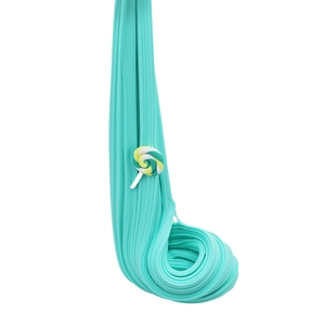 Teal cotton slime with a colorful lollipop accessory being stretched over a white surface