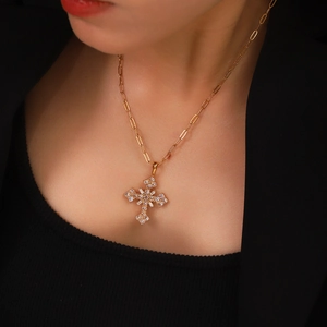 Détail d'un collier pendentif croix doré avec zircons sur une chaîne trombone
