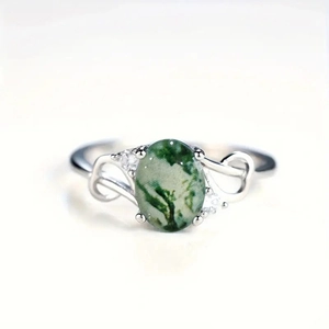 Detail view of silver ring with oval green moss agate stone and zircon accents