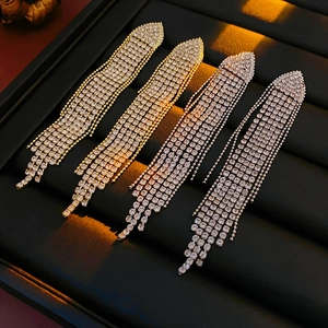 Macro detail of cascading geometric tassel earrings with glittering rhinestones