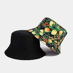 Close-up detail of double-sided bucket hat with vibrant lemon and berry floral pattern