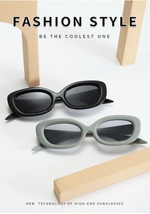 Flat lay view of oval fashion sunglasses in black and grey-green on wooden props