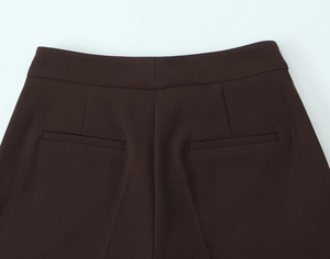 Close-up of dark brown trousers featuring white side stripes and detailed back pocket stitching