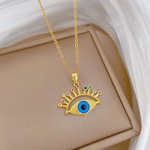 Macro detail of gold evil eye necklace with colorful crystals on a jewelry box