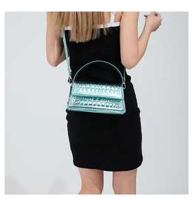 Detail of cyan metallic crossbody bag with crocodile embossing and detachable strap