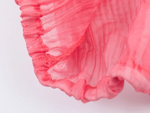 Close-up of pink ruffled chiffon fabric with elastic hem and pleated texture detail