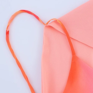 Close-up detail of smooth orange-pink fabric stitching and thin shoulder strap design