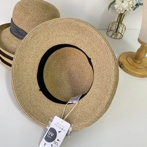 Detail of woven straw hat interior featuring black sweatband and UV protection tag