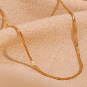 Close-up of 2mm 18K gold plated stainless steel snake chain on soft silk fabric