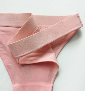 Macro shot of breathable pink cotton fabric and elastic waistband of women's briefs