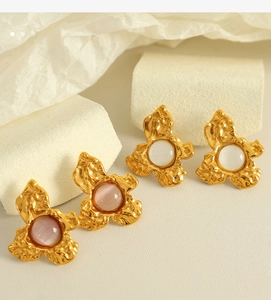 Detailed close-up of French vintage gold flower earrings with pink and white cat eye stones