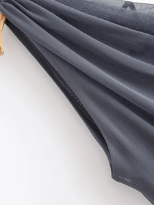 Close-up of breathable dark gray mesh fabric texture on asymmetrical ruched top