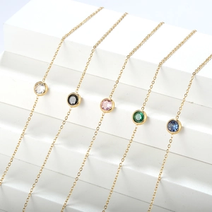 Dettaglio di zirconi rotondi colorati incastonati in catena d'acciaio placcata oro 18K