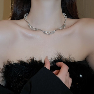 Detail view of lace pattern diamond necklace worn on collarbone with sparkling rhinestones