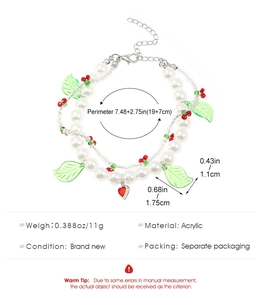Detail of double-layer white pearl necklace featuring red acrylic cherry charms