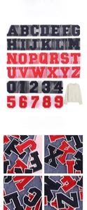 Macro view of navy and red embroidered alphabet patches with 3D towel texture on fabric