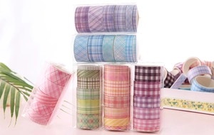 Detailed view of colorful plaid washi tape rolls in clear plastic boxes for DIY stationery
