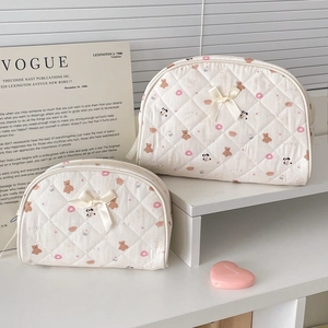 Detailed set of two quilted bear print cosmetic bags featuring cute silk bow accents