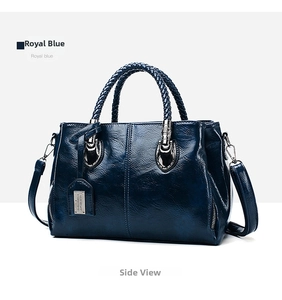 Detail of royal blue oil wax leather Boston bag with woven handles and silver accents