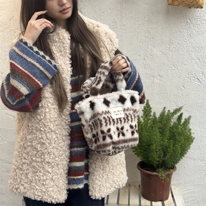 Detailed plush tote bag texture with brown geometric patterns and brand label on white faux fur