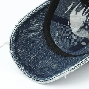 Détail du tissu denim délavé et des bords effilochés sur la visière de la casquette vintage