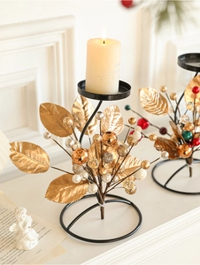 Macro detail of black metal Christmas candle holder with golden leaves and decorative beads