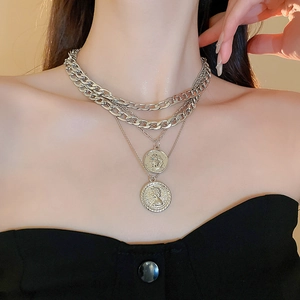Multi-layered silver coin portrait pendant necklace with chunky Cuban chains on model