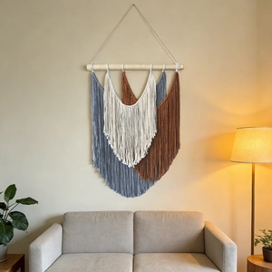 Tapisserie murale bohème tissée main avec glands bleus, crème et rouille sur bois