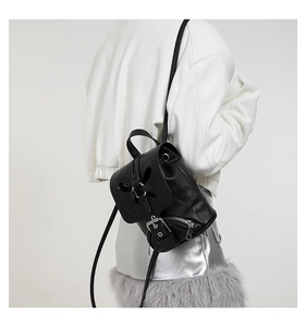 Détail d'un mini sac à dos en cuir noir avec découpe papillon et boucle métallique