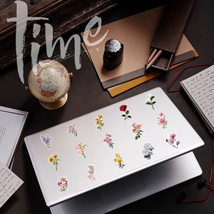 Floral PET stickers featuring roses and lilies applied to a silver laptop cover