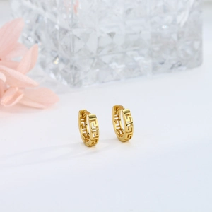 Macro shot of gold S925 sterling silver earrings with meander greek pattern details