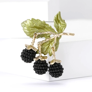 Detail of creative alloy blackberry brooch with black enamel berries and green leaves