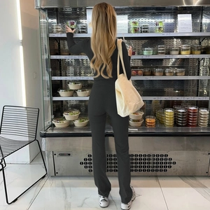 Detail shot of black slim fit top and high waist flared pants set in a modern store setting