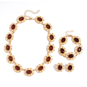 Vintage gold jewelry set with red oval stones and small white flower details