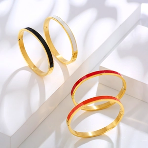 Detail view of colorful enamel and gold plated stainless steel bangles in four colors