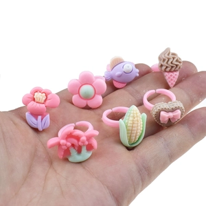 Close-up of children's colorful resin rings with cute cartoon designs like flowers and fish