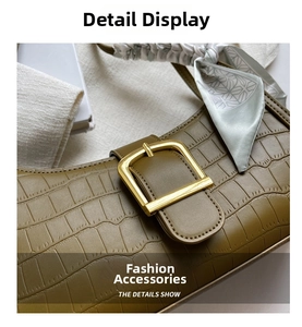 Detail of green faux crocodile skin bag with golden buckle and stylish silk scarf