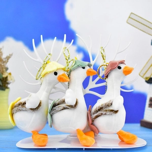Vue détaillée de trois porte-clés oies en peluche avec chapeaux et sacs colorés